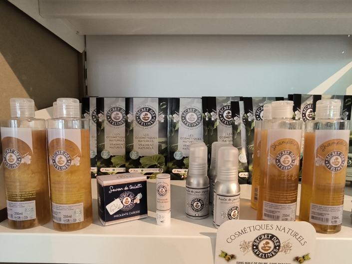 COSMETIQUE NATUREL SECRET DES AVELINES Gamme de cosmétiques naturels artisanaux de la marque Le Secret des Avelines présentée en rayon, avec shampoings, huiles, savons et soins visage.